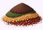 A small pile of four different ground spices arranged in layers by color: brown, green, yellow, and red.
